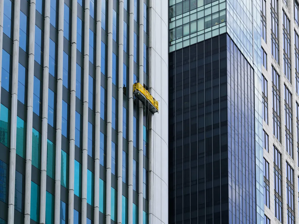 Eine Fensterreinigung an einem Hochhaus mit einem Kran